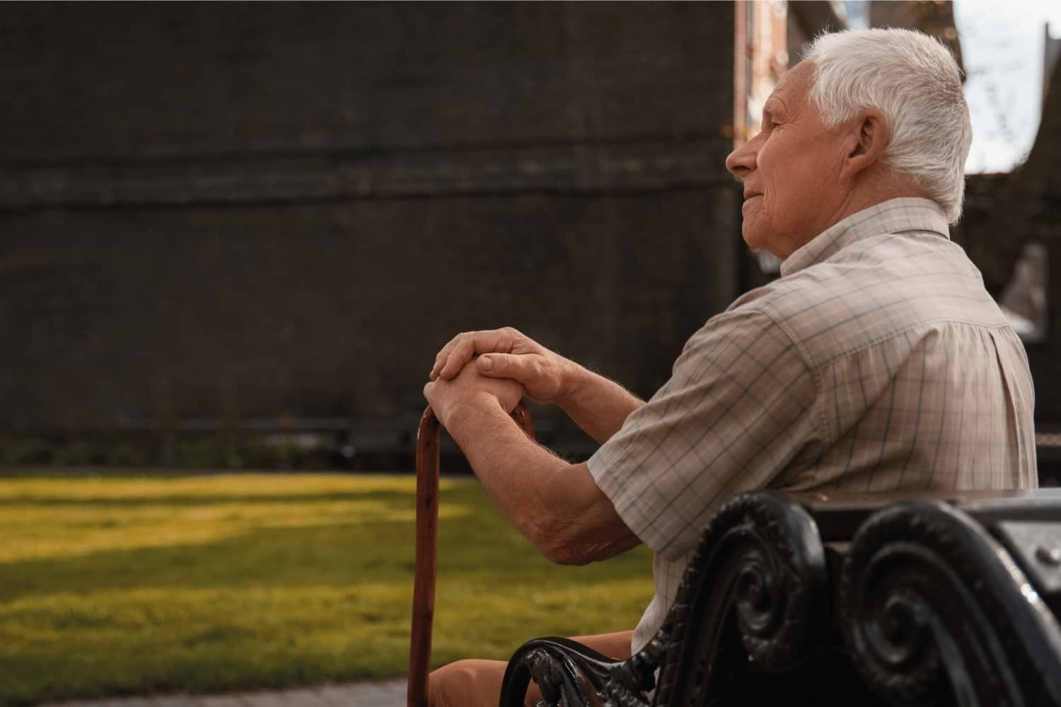 Un senior perdu dans ses pensées assis dans un parc.