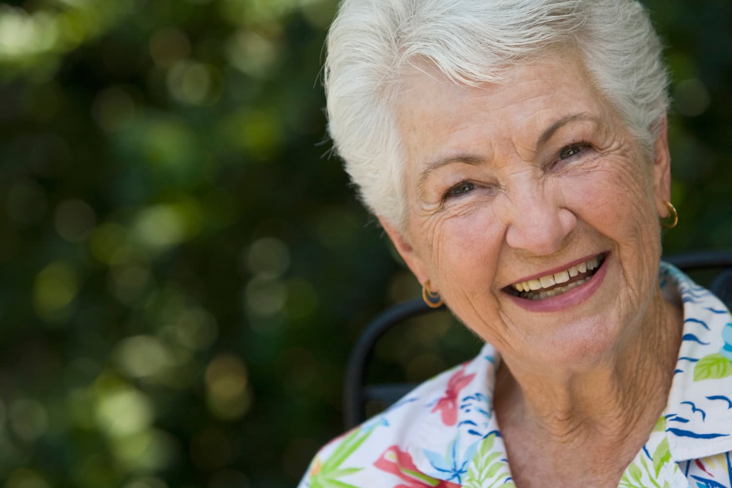 senior lady smiling with a flowers shirt